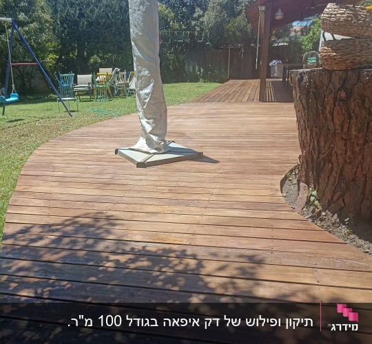 דק עץ בגינה עם שמשיה מקופלת